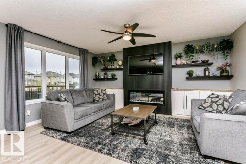 Living area featuring light wood-finish flooring and a contemporary ceiling fan - 42 Santana Crescent, Fort Saskatchewan, AB - Indoor Photo Showing Living Room