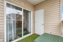 Exterior balcony featuring vinyl siding, a white sliding glass door, a white paneled exterior door, and a textured ceiling - 73 3040 Spence Wynd, Edmonton, AB  - Outdoor With Exterior 