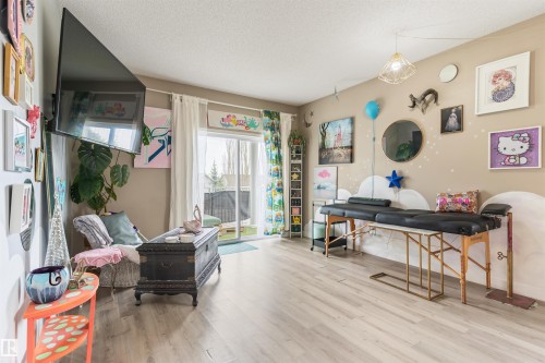 Bright interior space featuring light wood-finish flooring, a neutral wall color, and white trim - 73 3040 Spence Wynd, Edmonton, AB - Indoor