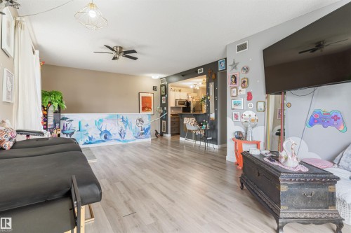 Open-concept living area featuring wood-finish flooring, recessed lighting, and a ceiling fan - 73 3040 Spence Wynd, Edmonton, AB - Indoor