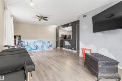 Open-concept living area featuring wood-finish flooring, a contemporary ceiling fan, and recessed lighting - 