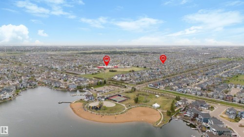 Aerial perspective showcasing a residential community with a large central lake - 73 3040 Spence Wynd, Edmonton, AB - Outdoor With Body Of Water With View