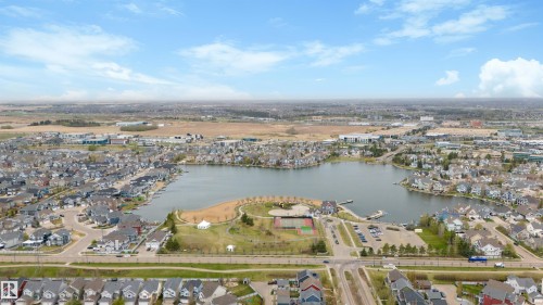 Expansive aerial capturing a community surrounding a central lake - 73 3040 Spence Wynd, Edmonton, AB - Outdoor With Body Of Water With View