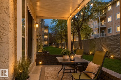 Covered patio featuring string lighting and an exterior wall light - 104 9760 174 Street, Edmonton, AB - Outdoor With Deck Patio Veranda