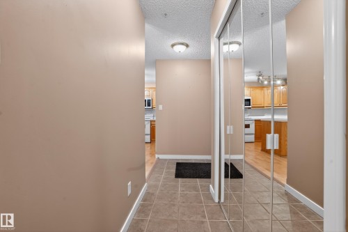 Entryway featuring tile flooring, mirrored closet doors, and overhead flush-mount lighting - 104 9760 174 Street, Edmonton, AB - Indoor Photo Showing Other Room