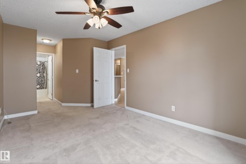 Spacious room featuring neutral carpeting and tan walls - 104 9760 174 Street, Edmonton, AB - Indoor Photo Showing Other Room