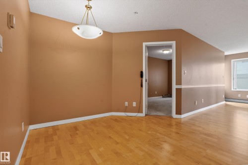 Hardwood flooring extending throughout the space - 104 9760 174 Street, Edmonton, AB - Indoor Photo Showing Other Room
