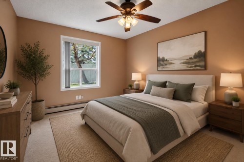 Neutral-toned bedroom featuring a ceiling fan with integrated lighting, a large window, baseboard heating, and light-colored carpeting - 104 9760 174 Street, Edmonton, AB - Indoor Photo Showing Bedroom