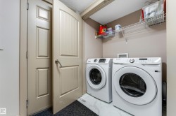 Dedicated laundry area featuring a white washing machine and dryer, a wire shelf for storage, and light-colored walls - 