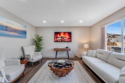 The living room features recessed lighting, durable plank flooring, and a large sliding glass door - 