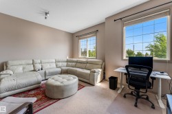 This versatile room features warm neutral wall tones and two windows, providing natural light - 