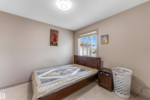 The property features a bedroom with a window, carpeting, and light-colored walls - 463 Tamarack Green, Edmonton, AB - Indoor Photo Showing Bedroom