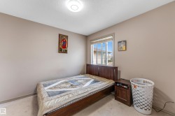 The property features a bedroom with a window, carpeting, and light-colored walls - 