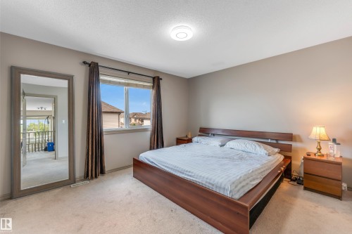 This room features wall-to-wall carpeting and a window with curtains and a view of surrounding structures - 463 Tamarack Green, Edmonton, AB - Indoor Photo Showing Bedroom