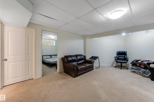 Carpeted room featuring a drop ceiling with recessed lighting and a flush mount ceiling light - 463 Tamarack Green, Edmonton, AB - Indoor