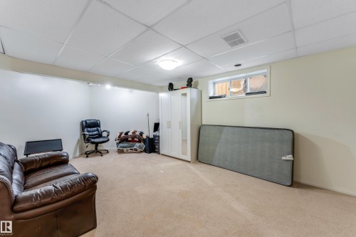 This versatile room features neutral carpeting, light-colored walls, recessed lighting, and a window - 463 Tamarack Green, Edmonton, AB - Indoor Photo Showing Basement