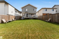 The property features a spacious backyard with a well-maintained lawn and a wooden fence - 