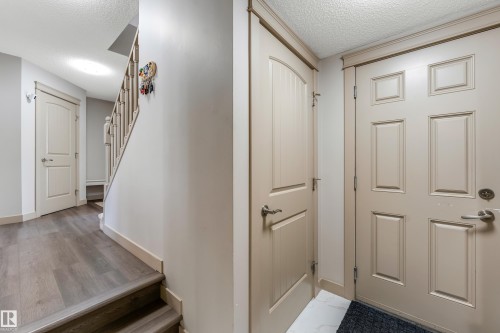 The entry features a paneled door and light-colored walls - 463 Tamarack Green, Edmonton, AB - Indoor Photo Showing Other Room