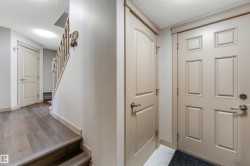 The entry features a paneled door and light-colored walls - 