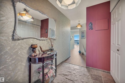 Foyer featuring slate tile flooring, a decorative wall mirror, and textured wall finishes - 1603 10025 113 Street, Edmonton, AB - Indoor Photo Showing Other Room