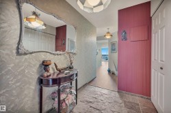 Foyer featuring slate tile flooring, a decorative wall mirror, and textured wall finishes - 