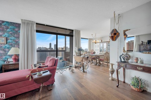 Living area featuring dark wood-finish flooring and expansive windows - 1603 10025 113 Street, Edmonton, AB - Indoor