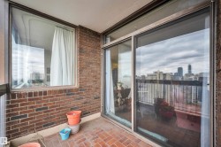 Private balcony featuring a brick wall, brick-patterned flooring, and a sliding glass door - 