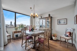 Dining area featuring expansive window, wood-finish flooring, and a multi-arm chandelier - 
