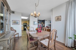 Dining area featuring wood-finish flooring, a traditional chandelier, and light-colored walls - 