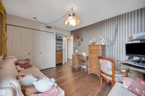 Wood-finish flooring throughout, complemented by a patterned accent wall - 1603 10025 113 Street, Edmonton, AB - Indoor