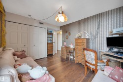 Wood-finish flooring throughout, complemented by a patterned accent wall - 