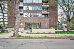 Multi-story building featuring a brick facade with multiple balconies and large windows - 