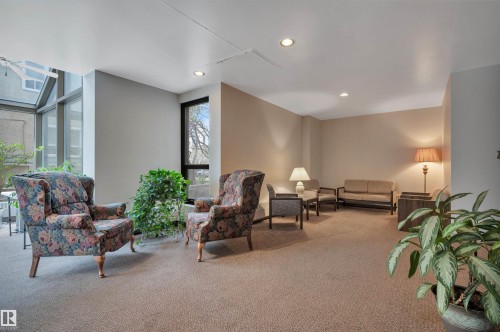 Carpeted common area featuring recessed lighting, large window panels, and a full-height window - 1603 10025 113 Street, Edmonton, AB - Indoor