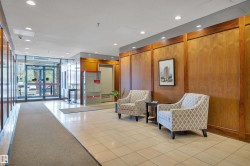 Building entryway featuring large glass doors, recessed lighting, and wood paneling - 