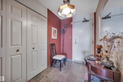 Tiled entry foyer with red accent wall and neutral bi-fold closet doors - 