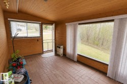 Wood-paneled room with an angled wood-finish ceiling, featuring a patterned brick-look floor - 