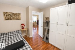 Room featuring light neutral wall paint, wood-finish flooring, white baseboards, and a white ceiling - 