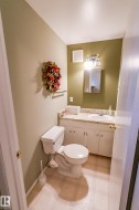Bathroom vanity with an integrated sink, a light-colored countertop, and white cabinetry - 