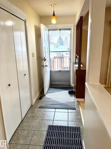 Inviting entryway featuring tile flooring, a functional closet, and a decorative pendant light fixture - 15208 92 Street, Edmonton, AB - Indoor Photo Showing Other Room