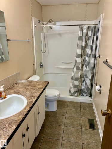 Bathroom featuring a vanity with a sink, a toilet, and a shower with a tub - 15208 92 Street, Edmonton, AB - Indoor Photo Showing Bathroom