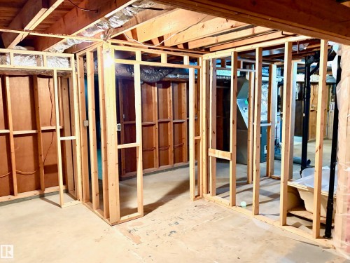 The basement features exposed wooden ceiling joists and wall framing, with a concrete floor - 15208 92 Street, Edmonton, AB - Indoor Photo Showing Basement