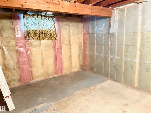 Unfinished basement space featuring exposed wooden beams, concrete flooring, and insulated walls - 15208 92 Street, Edmonton, AB - Indoor Photo Showing Basement