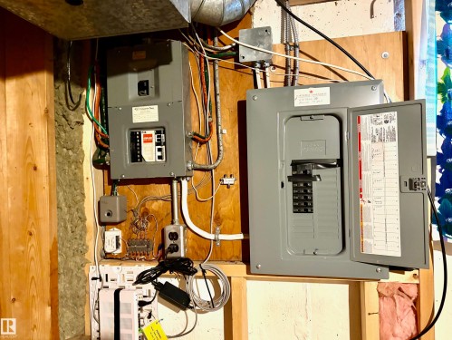 The property features electrical panels and wiring, indicative of essential utility infrastructure - 15208 92 Street, Edmonton, AB - Indoor Photo Showing Basement