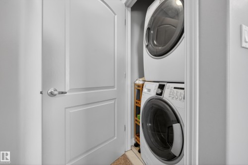Dedicated laundry closet featuring a stacked washer and dryer - 7074 Cardinal Way, Edmonton, AB - Indoor Photo Showing Laundry Room