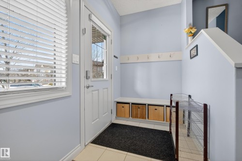 Entryway with light blue walls, white trim, and light-colored tile flooring - 7074 Cardinal Way, Edmonton, AB - Indoor Photo Showing Other Room