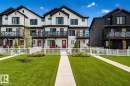 Modern townhome exterior with crisp white siding and contrasting black trim - 38 Jensen Gate, St. Albert, AB  - Outdoor With Balcony With Facade 