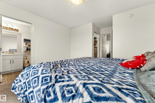 Bedroom featuring a ceiling-mounted light fixture, warm-toned carpet, and white walls - 38 Jensen Gate, St. Albert, AB - Indoor Photo Showing Bedroom