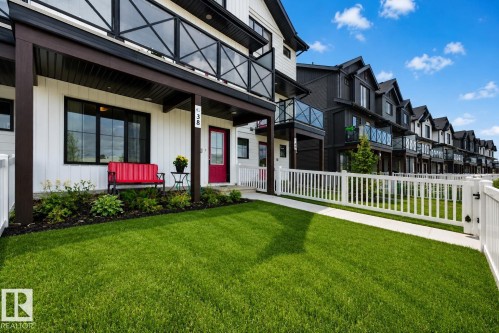 Modern townhome exterior featuring vertical white siding and black trim accents - 38 Jensen Gate, St. Albert, AB - Outdoor