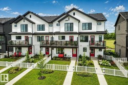 Contemporary townhome exterior featuring white vertical siding with dark trim - 