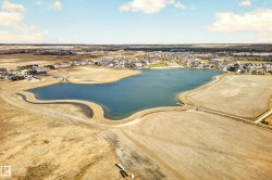 Aerial perspective showcasing a community lake with surrounding land and residential properties - 